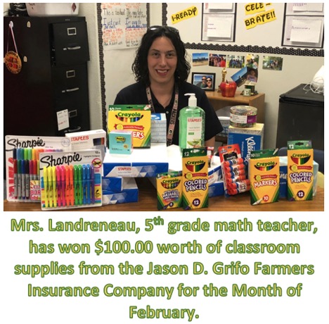A teacher sitting at her desk with various supplies in front of her. 